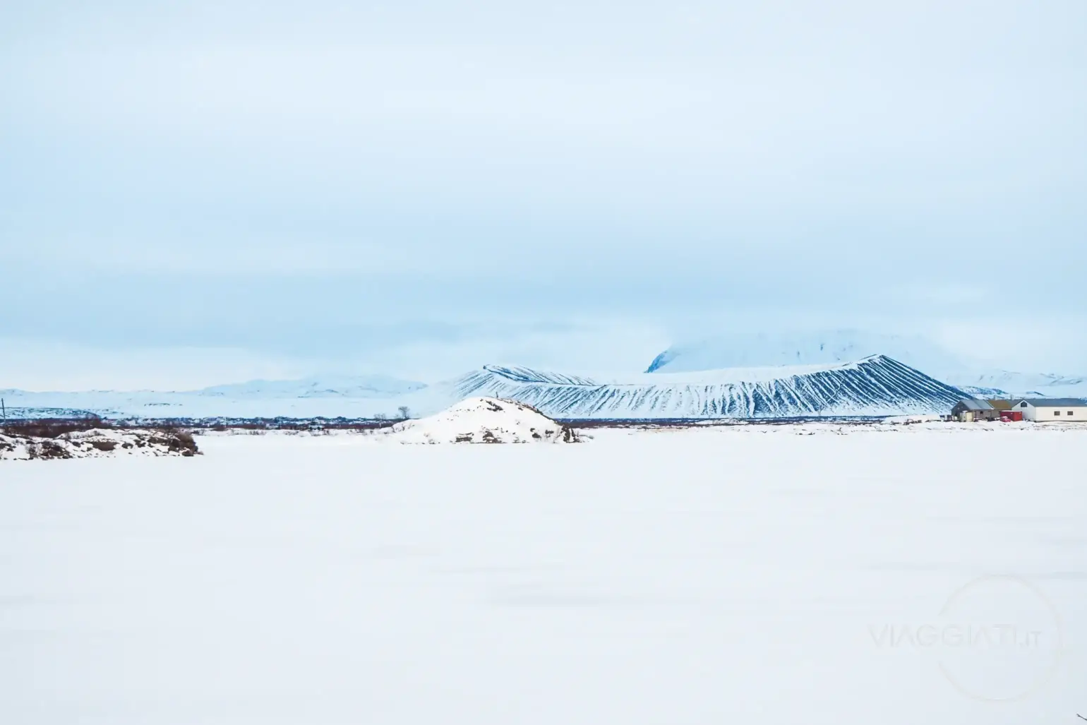 Panoramica del lago Mývatn ghiacciato con il cratere Hverfjall sullo sfondo